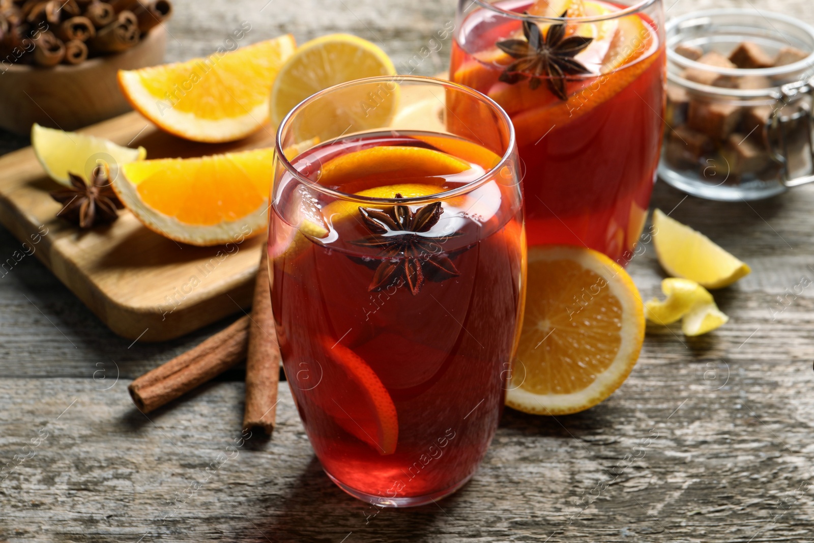 Photo of Aromatic punch drink and ingredients on wooden table