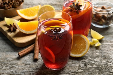 Photo of Aromatic punch drink and ingredients on wooden table