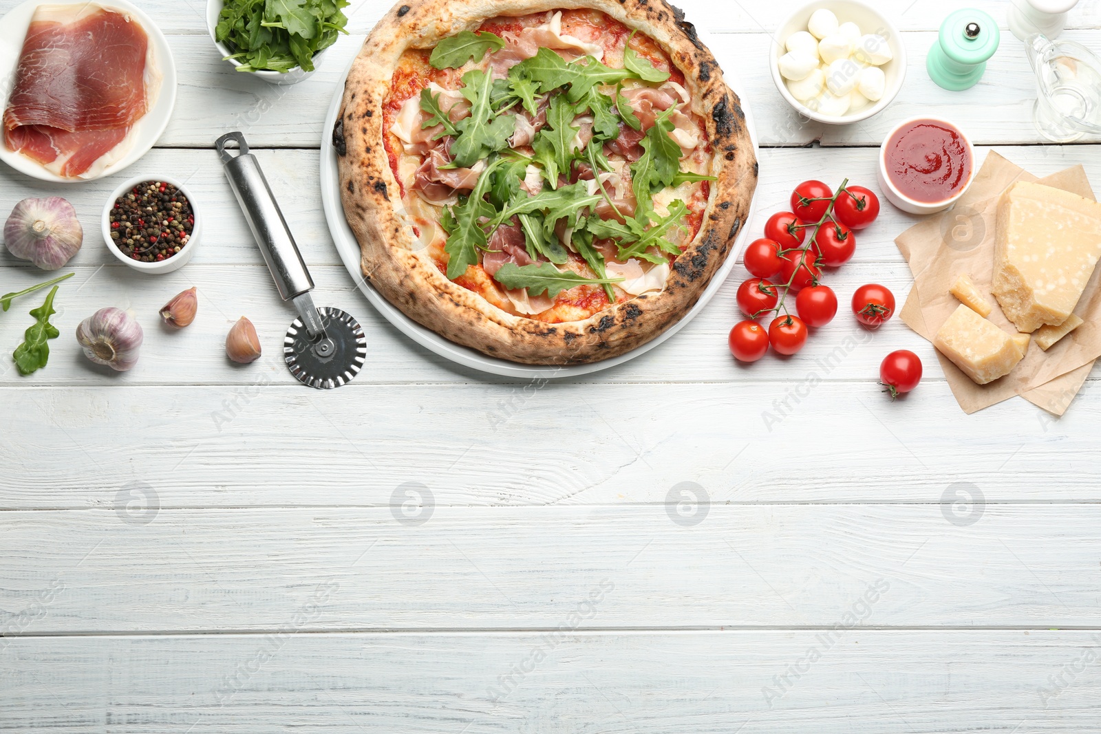 Photo of Tasty pizza with meat and arugula on white wooden table, flat lay. Space for text