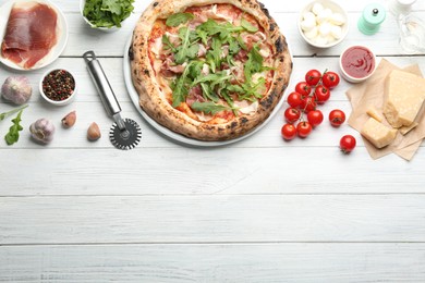 Tasty pizza with meat and arugula on white wooden table, flat lay. Space for text