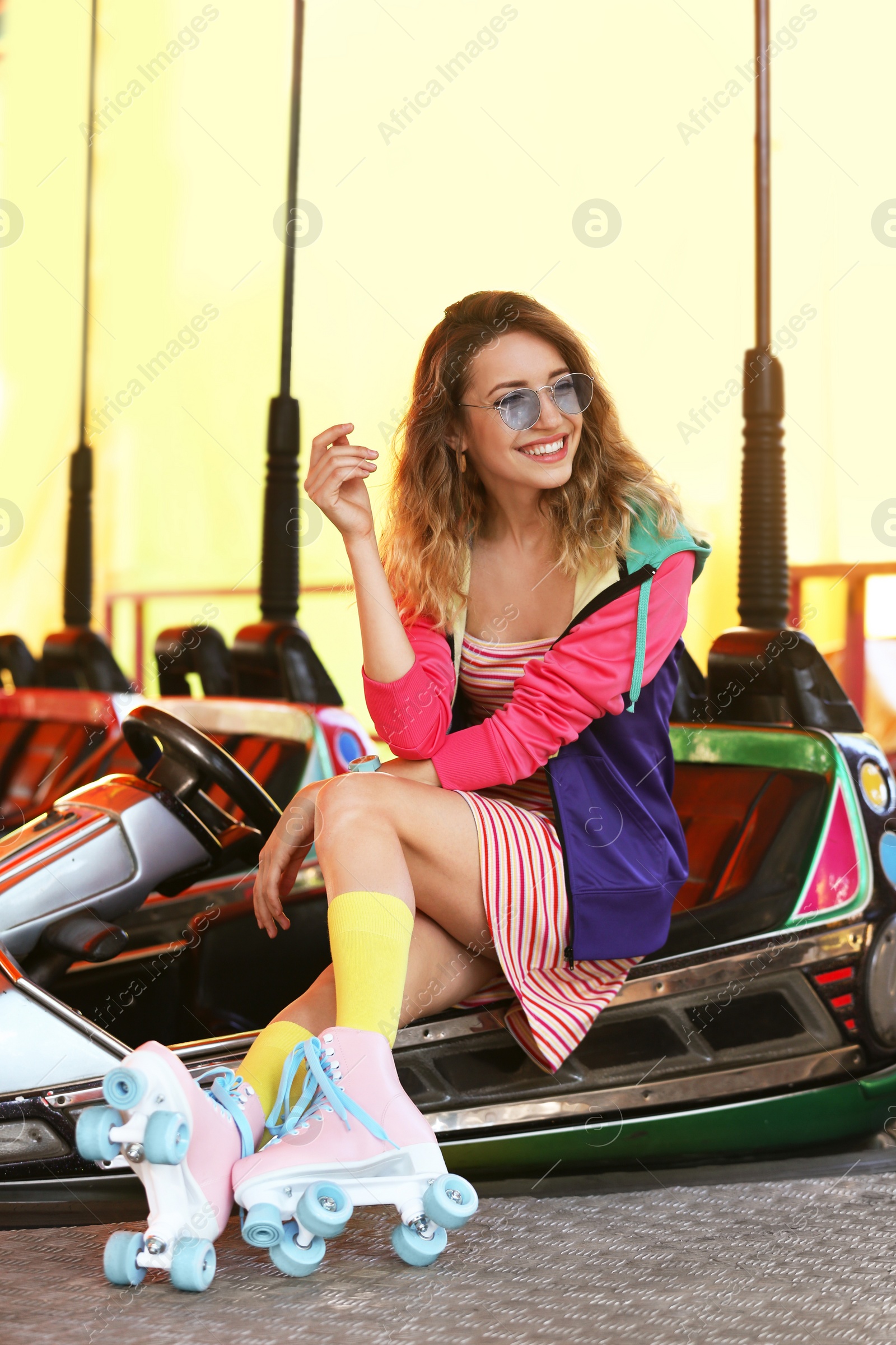 Photo of Happy girl with retro roller skates sitting in entertainment park