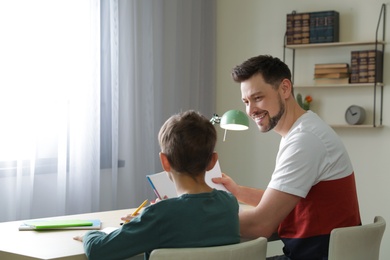 Dad helping his son with school assignment at home