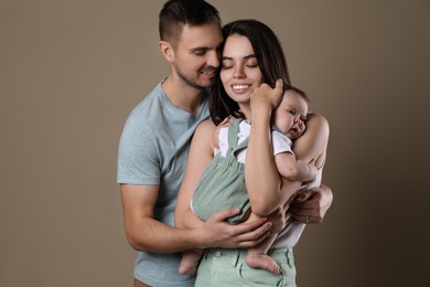 Photo of Happy family. Couple with their cute baby on beige background