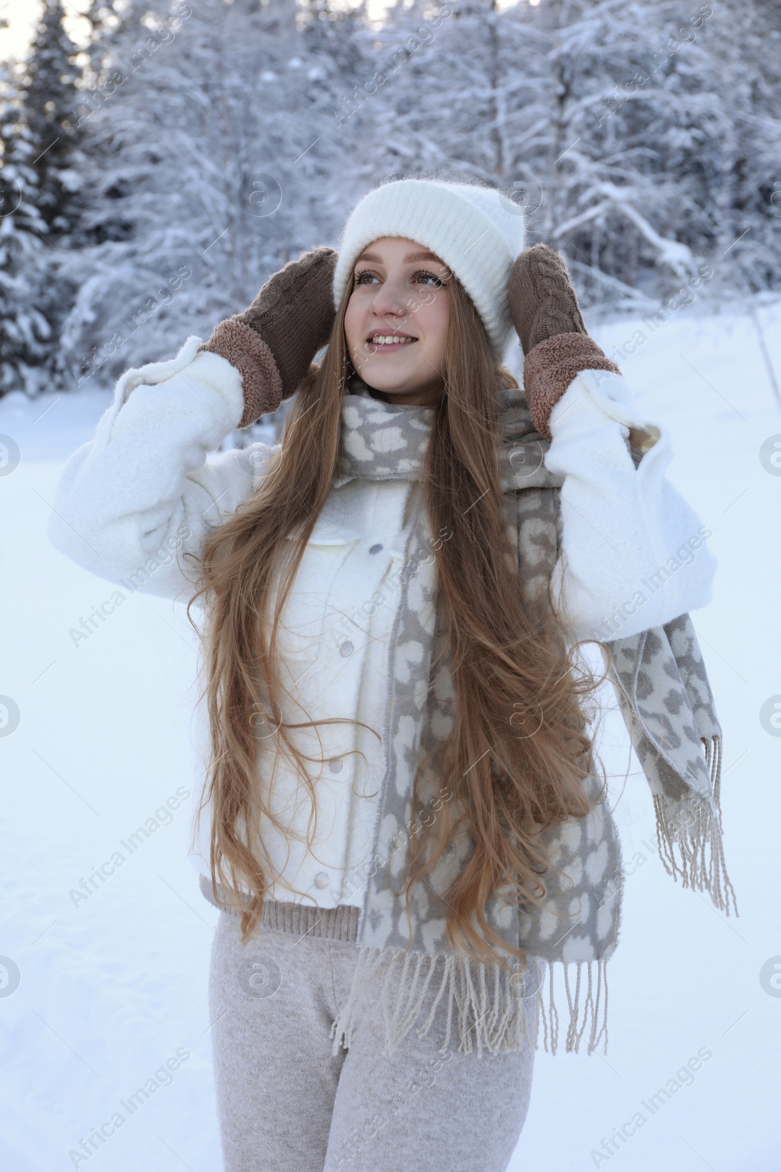 Photo of Winter vacation. Smiling woman near snowy forest outdoors