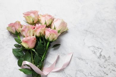 Photo of Beautiful bouquet of roses on white marble table, top view with space for text. Happy birthday greetings