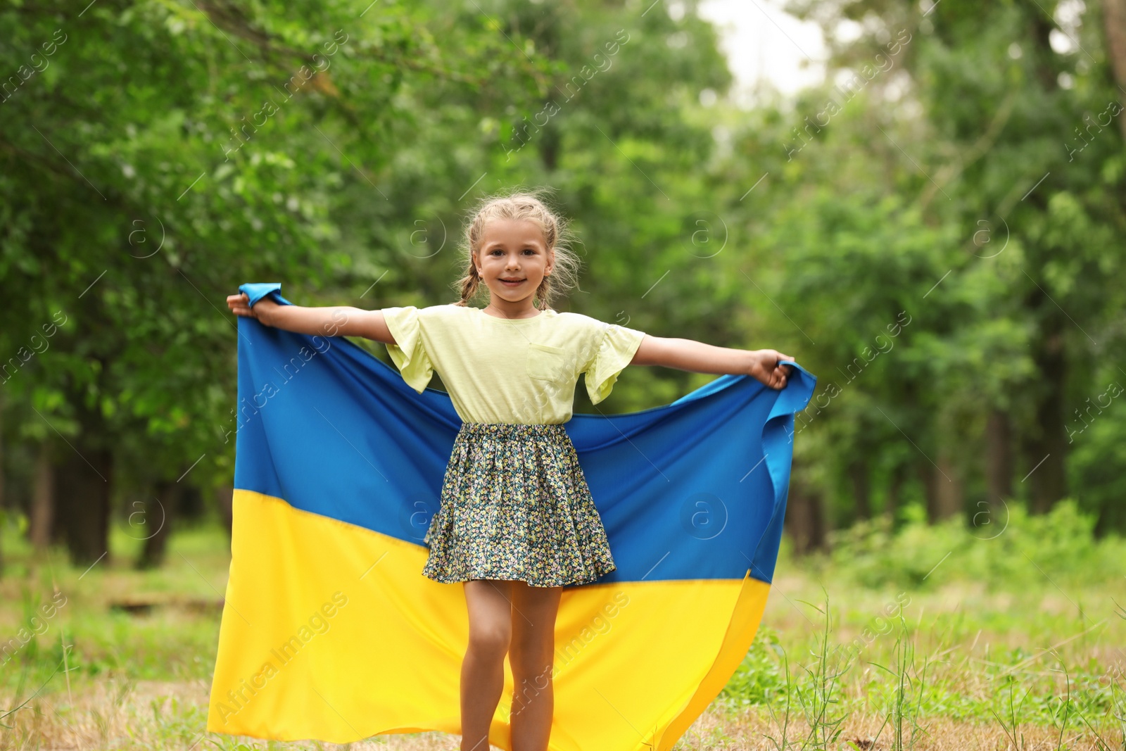 Photo of Little girl with flag of Ukraine outdoors