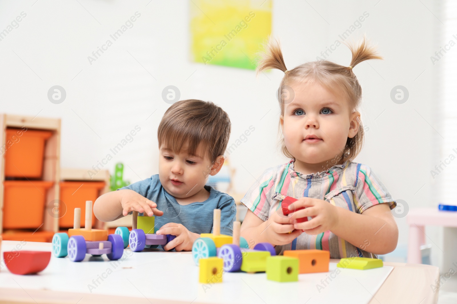Photo of Little children playing with construction set at table