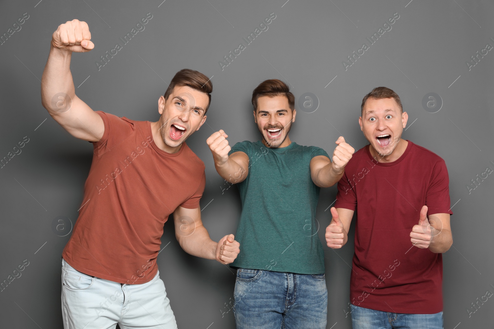 Photo of Group of friends celebrating victory against gray background