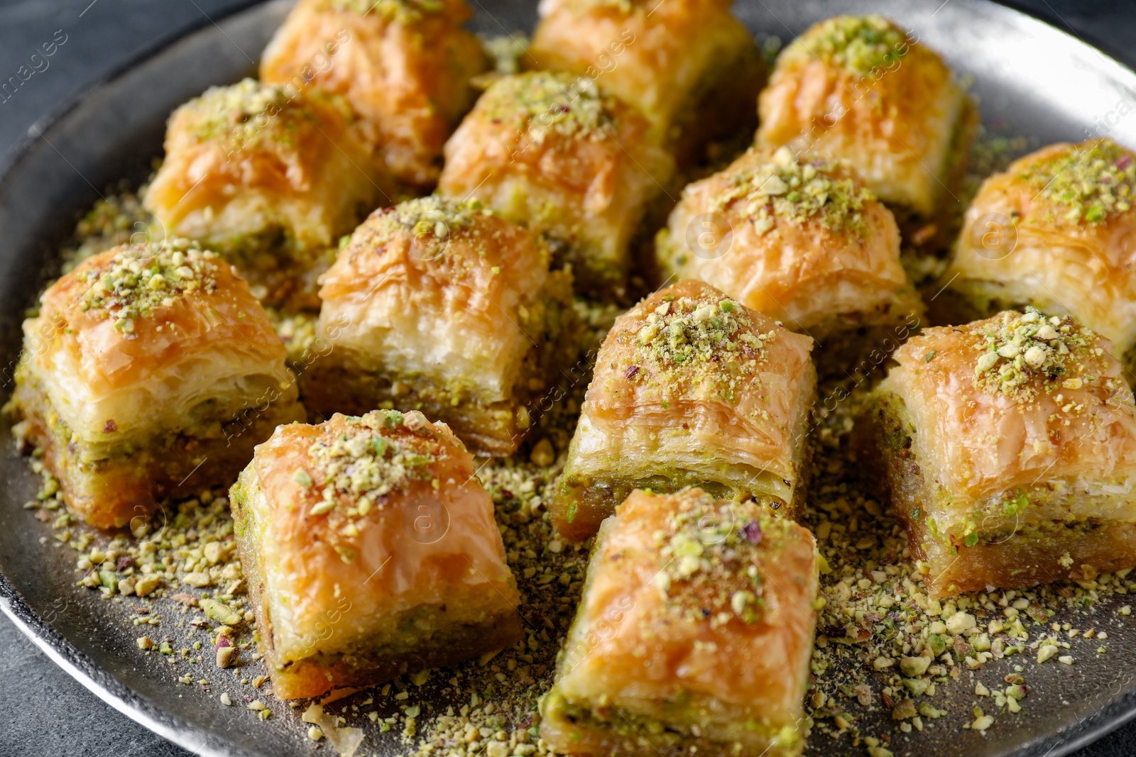 Photo of Delicious fresh baklava with chopped nuts on table, closeup. Eastern sweets