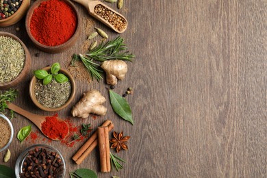 Photo of Different herbs and spices on wooden table, flat lay. Space for text