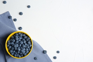 Photo of Crockery with juicy blueberries and space for text on white table, top view