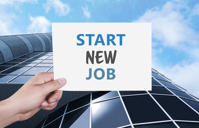 Image of Change your life. Man holding card with text Start New Job against modern building, closeup