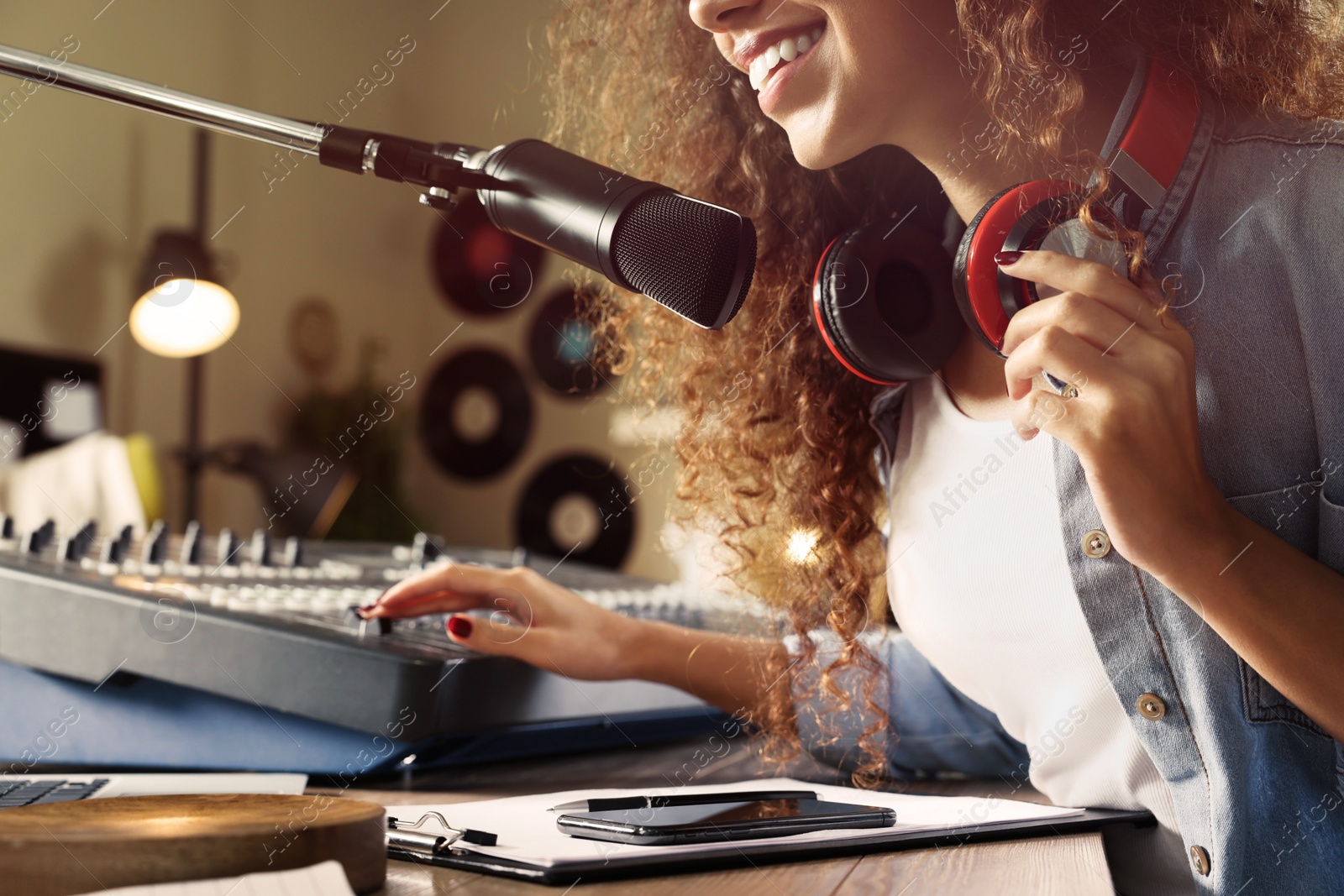 Photo of African American woman working as radio host in modern studio, closeup