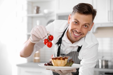 Professional chef presenting delicious dish in kitchen