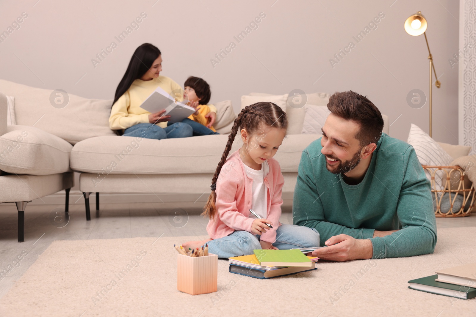 Photo of Happy family spending time together in living room