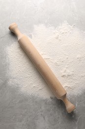 Photo of Pile of flour and rolling pin on grey marble table, top view