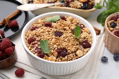 Photo of Tasty baked oatmeal with berries and nuts on table, closeup