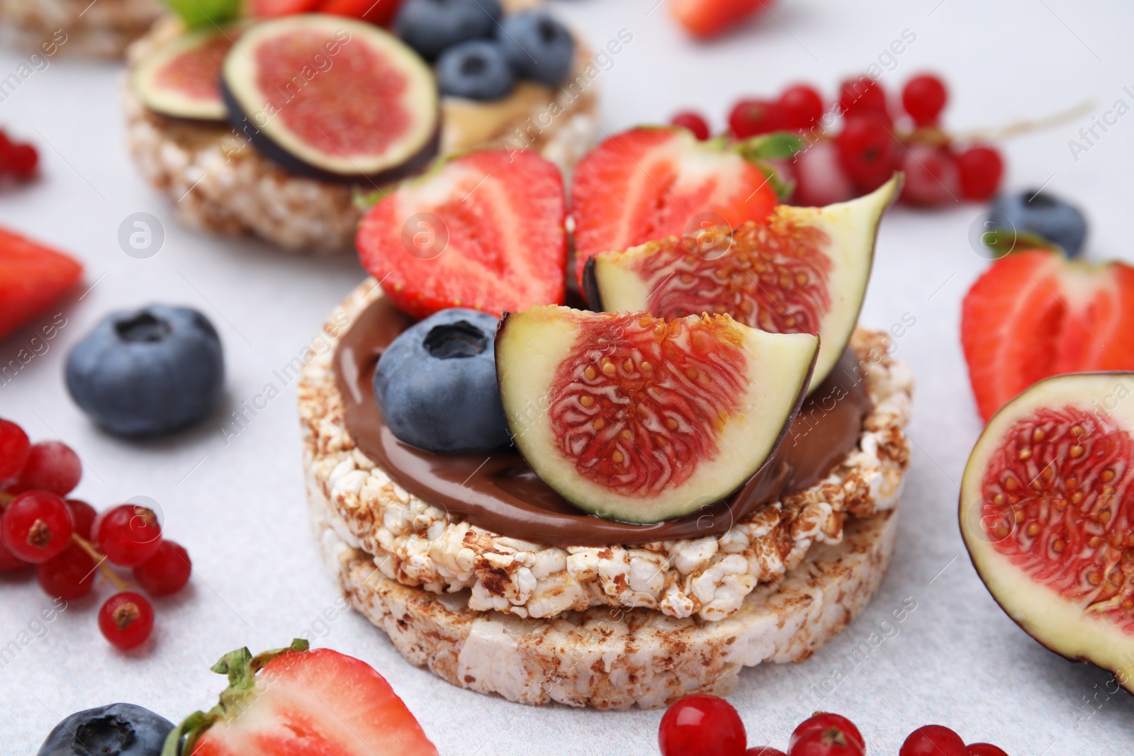 Photo of Tasty crispbreads with different toppings on light table, closeup