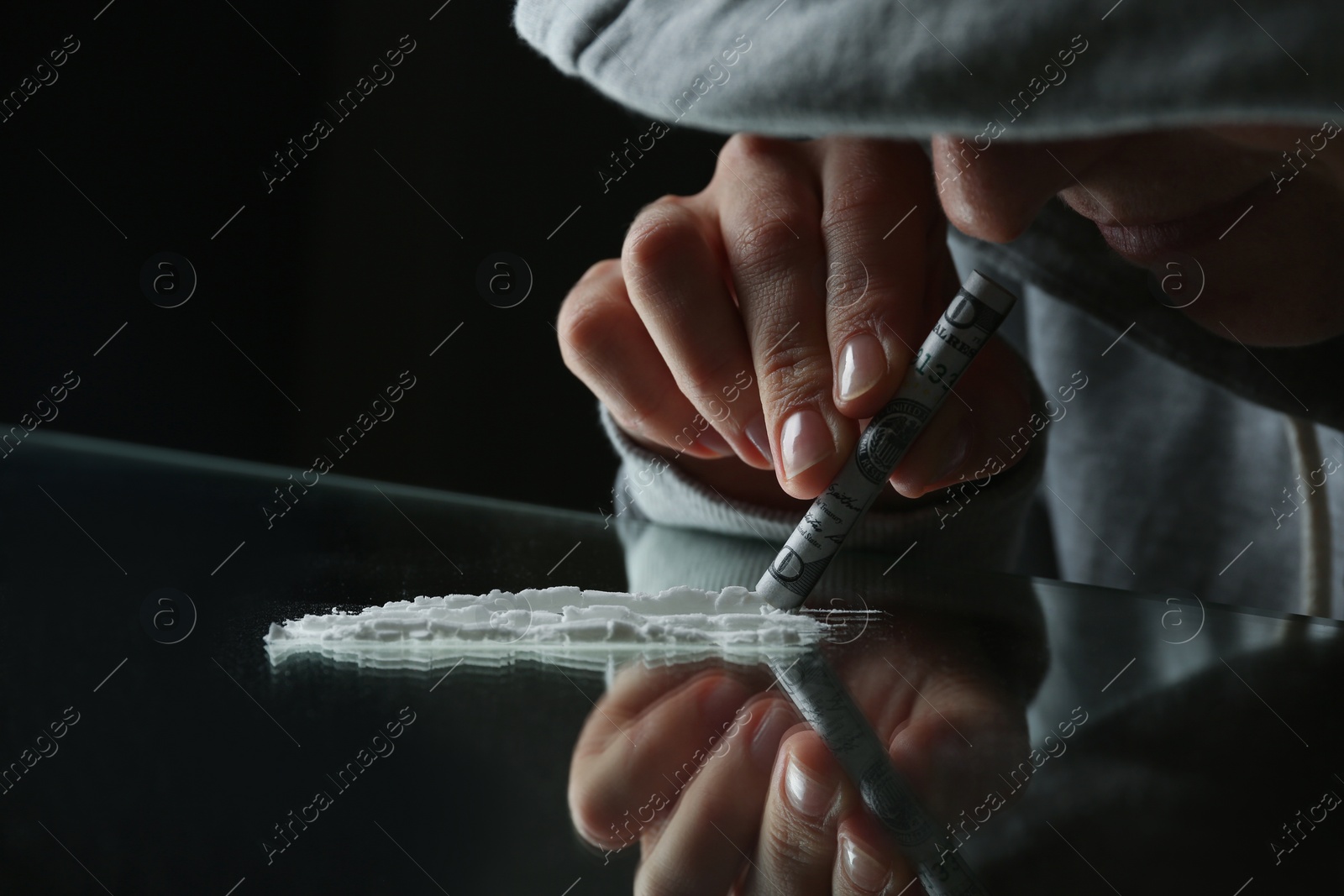 Photo of Drug addict taking cocaine at table, closeup view