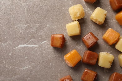 Photo of Different frozen fruit puree cubes on brown marble table, flat lay. Space for text