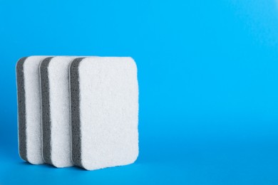 Photo of Sponges on light blue background. Space for text