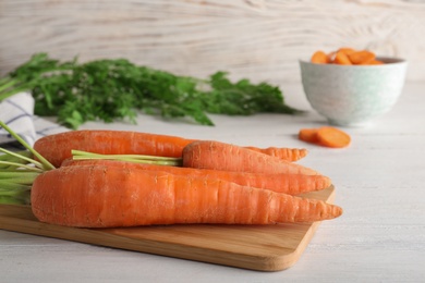 Photo of Cutting board with carrots on table. Space for text