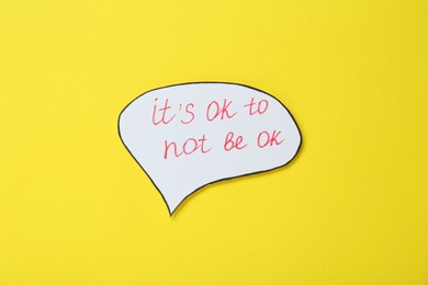 Card with phrase It`s Ok to Not Be Ok on yellow background, top view