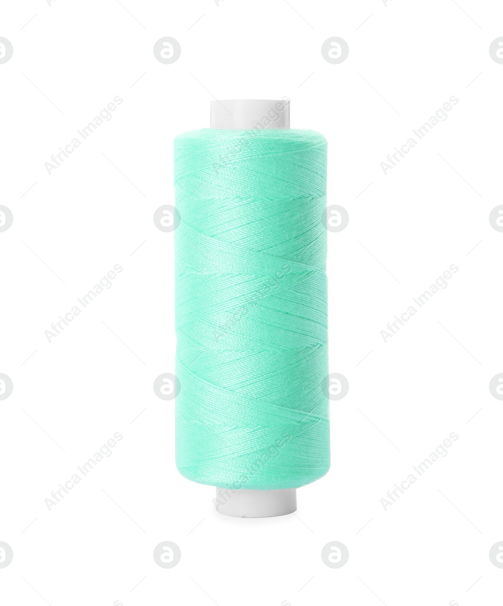 Photo of Spool of turquoise sewing thread isolated on white