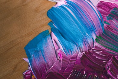 Photo of Colorful paints on wooden artist's palette, closeup