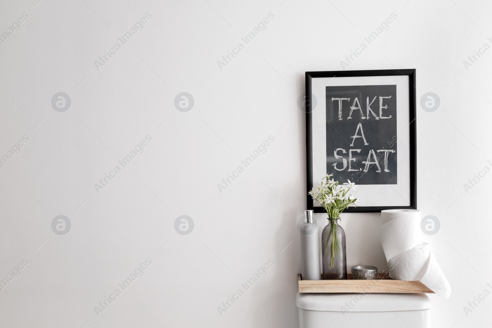 Photo of Decor elements, necessities and toilet bowl near white wall, space for text. Bathroom interior