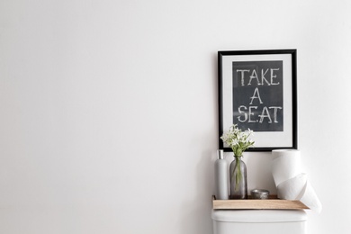 Decor elements, necessities and toilet bowl near white wall, space for text. Bathroom interior