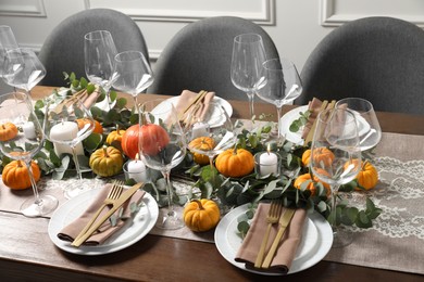 Photo of Beautiful autumn table setting. Plates, cutlery, glasses, pumpkins and floral decor