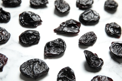 Photo of Dried plums on marble background. Healthy fruit