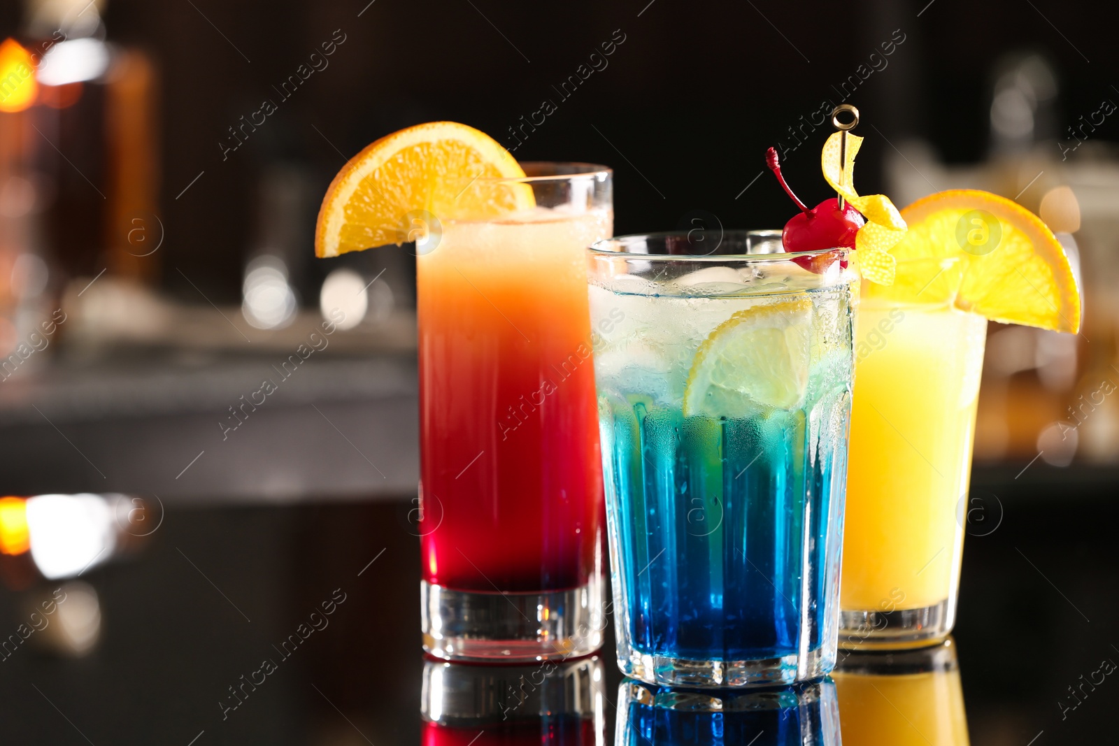 Photo of Different delicious cocktails on counter in bar