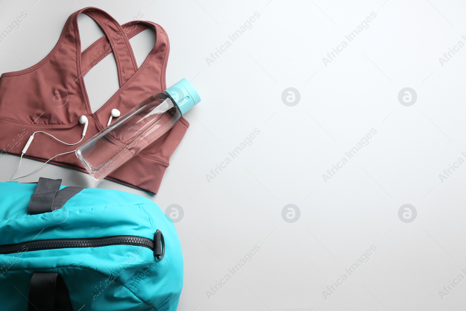 Photo of Flat lay composition with gym bag and sportswear on light grey background. Space for text