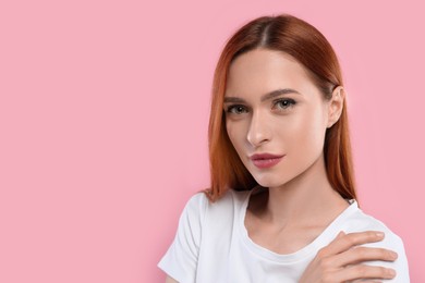 Portrait of beautiful young woman on pink background, space for text