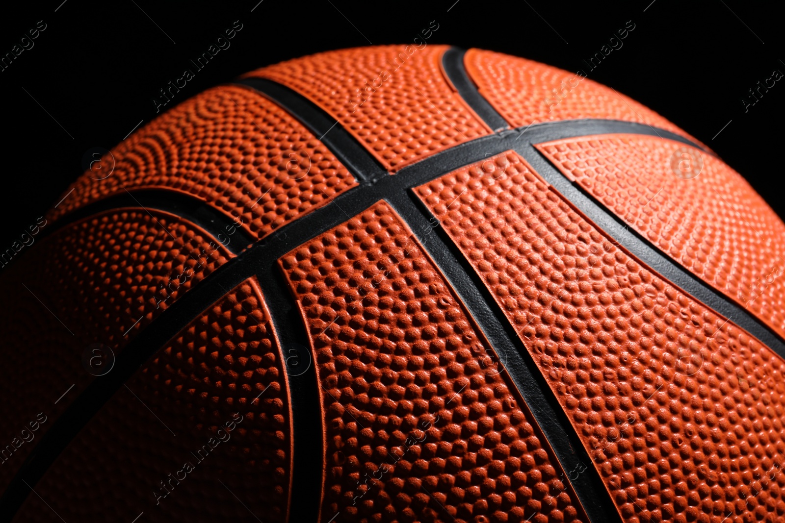 Photo of Orange basketball ball on black background, closeup