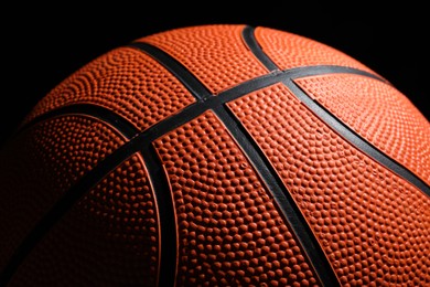 Orange basketball ball on black background, closeup