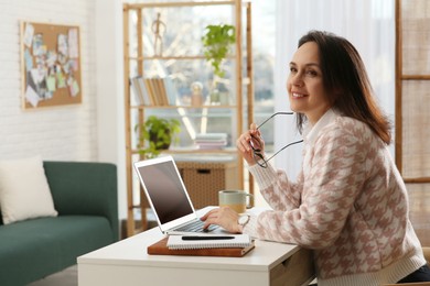 Photo of Woman with modern laptop learning at home