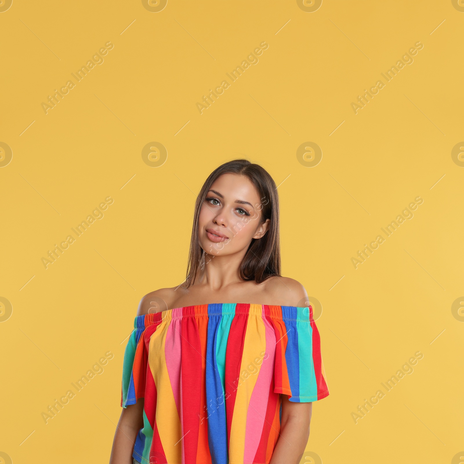 Photo of Portrait of beautiful young woman on yellow background