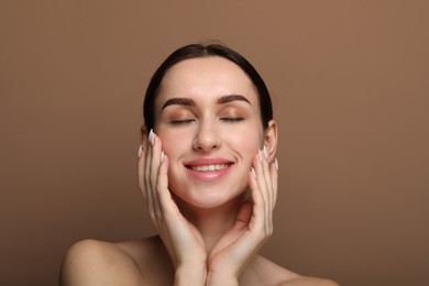 Photo of Portrait of beautiful young woman on brown background