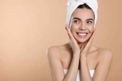 Young woman in towels on beige background, space for text. Spa treatment