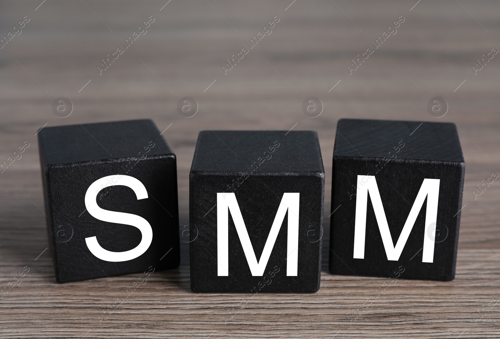 Photo of Cubes with abbreviation SMM (Social media marketing) on wooden table