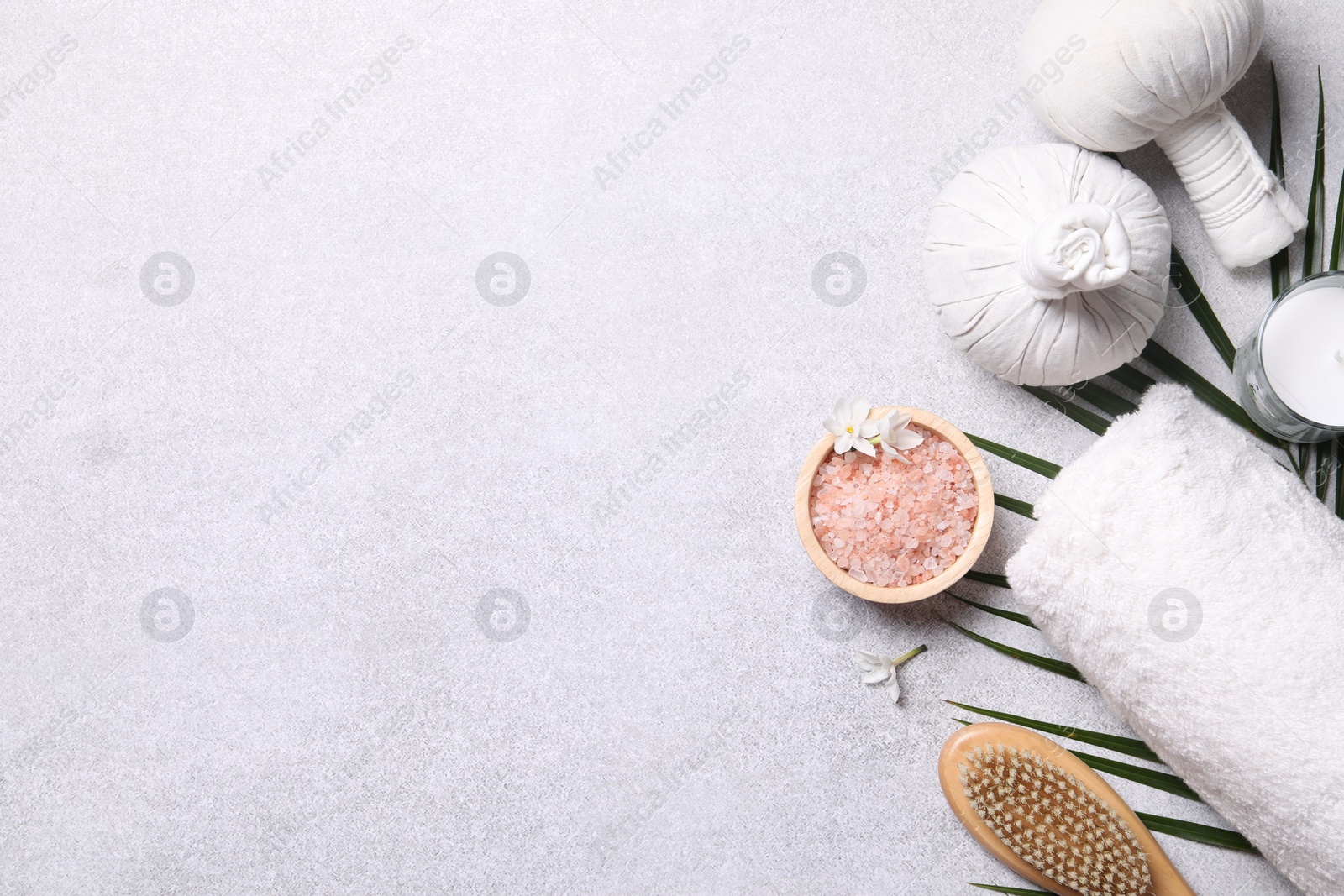 Photo of Flat lay composition with herbal massage bags and spa products on light grey table. Space for text