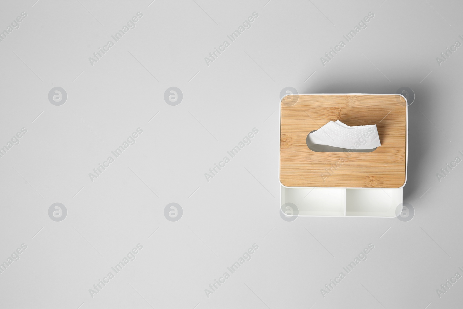 Photo of Holder with paper tissues on light grey background, top view. Space for text