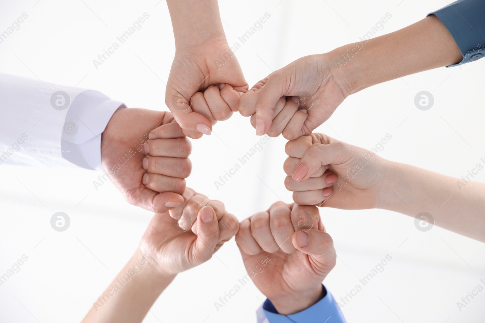 Photo of Team of medical doctors putting hands together indoors, bottom view