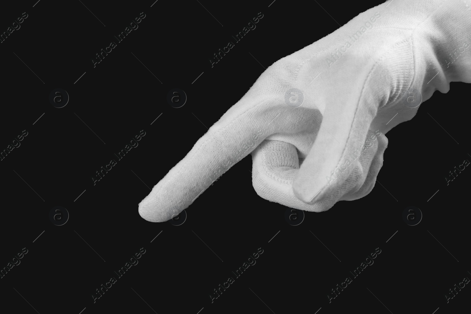 Photo of Person in white glove checking cleanliness of black background, closeup