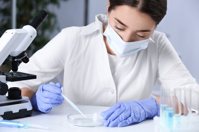 Photo of Scientist working with sample at white table in chemical laboratory