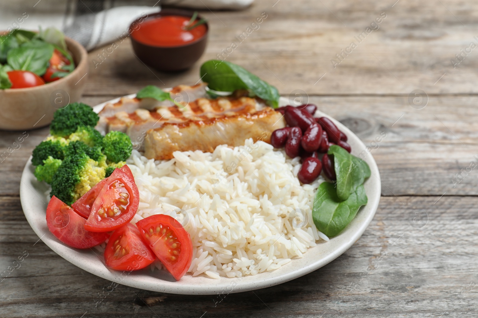 Photo of Tasty rice with beans and chicken meat on wooden table, closeup