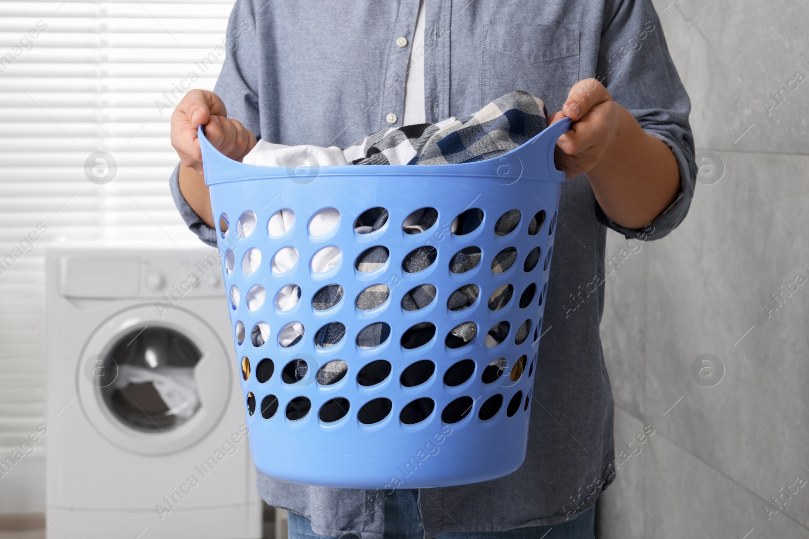 Photo of Man with basket full of laundry in bathroom, closeup